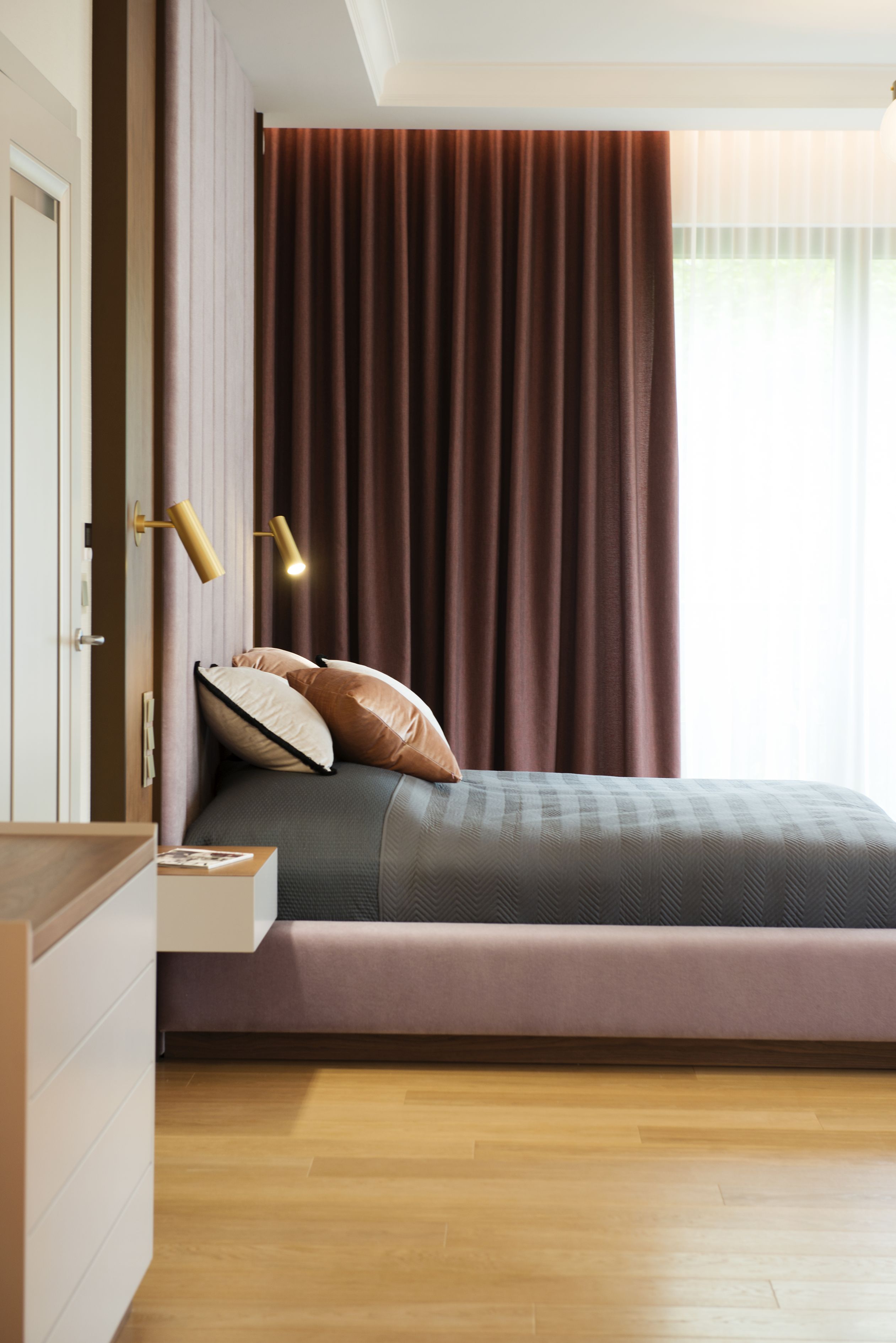 Kolor zasłon podkreśla drewno orzechowe na meblach.